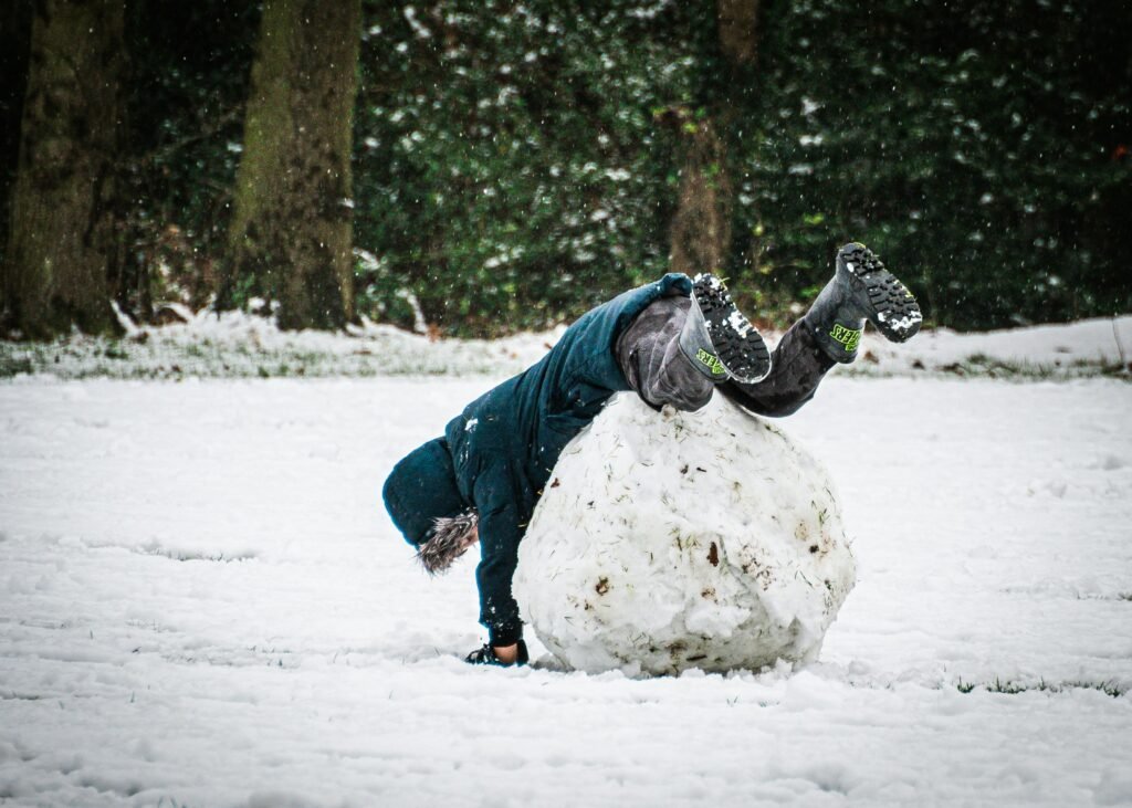 Boy falling over a snowball showing impact of compound interest