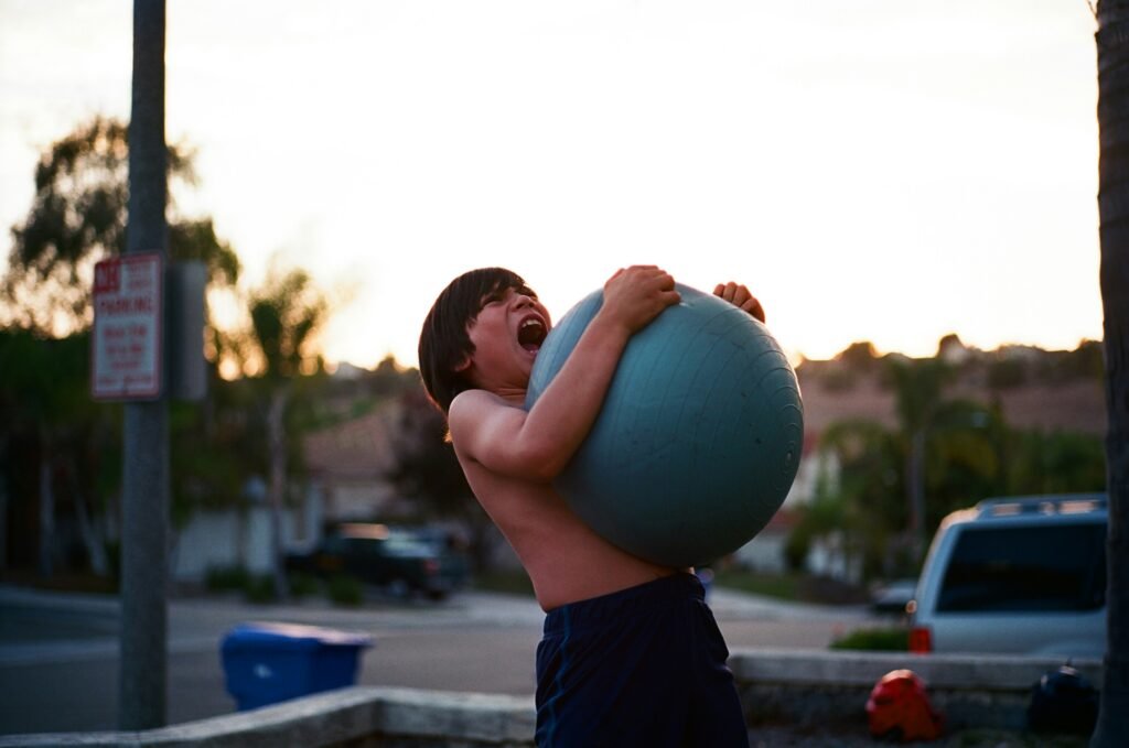 Boy lifting a ball showing strength and fighting against credit card compound interest